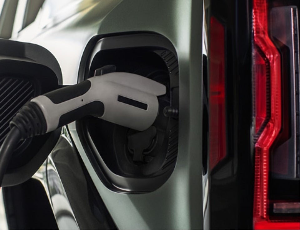 Close up of charging port with charger plugged in on a GMC Hummer EV SUV - Jensen GMC in NEW ULM MN